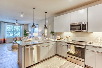 a kitchen with stainless steel appliances and granite counter tops at The Beck at Hidden River, Tampa, 33637
